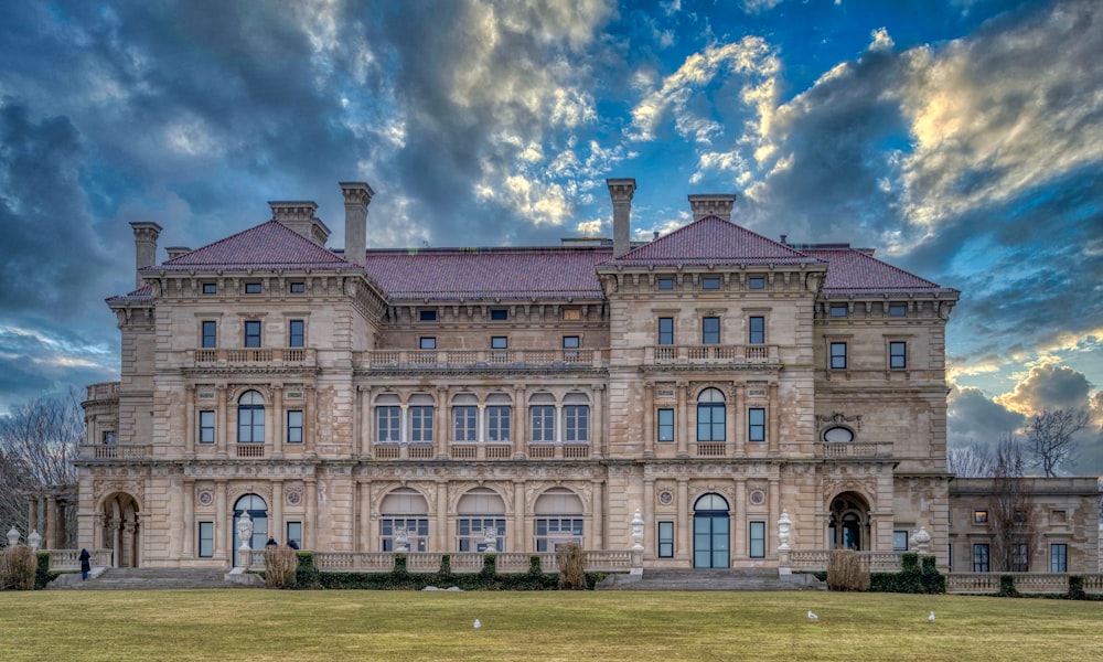 Braunes Betongebäude unter blauem Himmel und weißen Wolken tagsüber