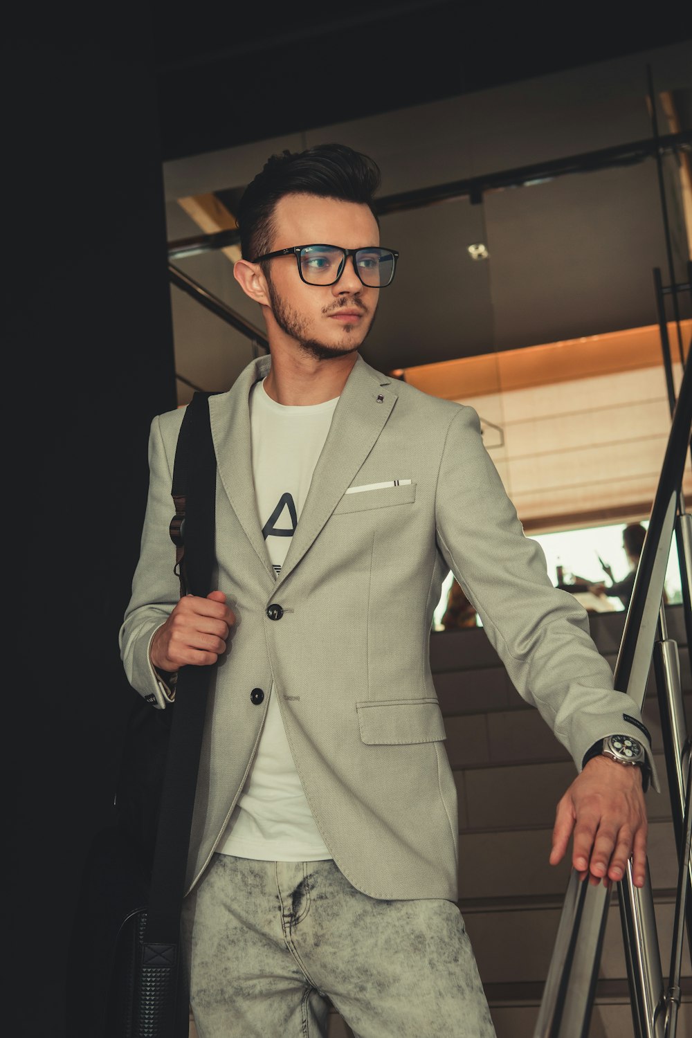 man in gray suit jacket wearing black framed eyeglasses