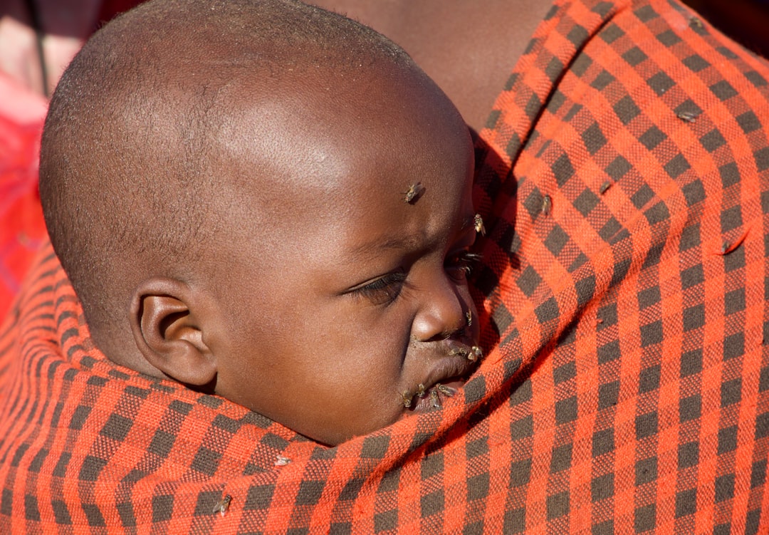 Maasai, Tanzania
Maasai baby cradled on mother’s back, flies. 