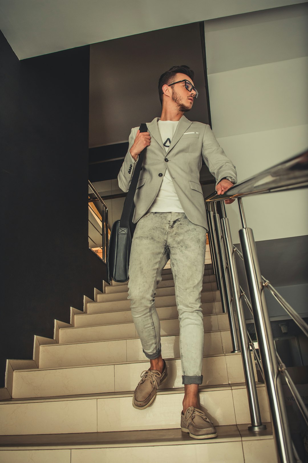 man in gray suit jacket and gray pants sitting on staircase