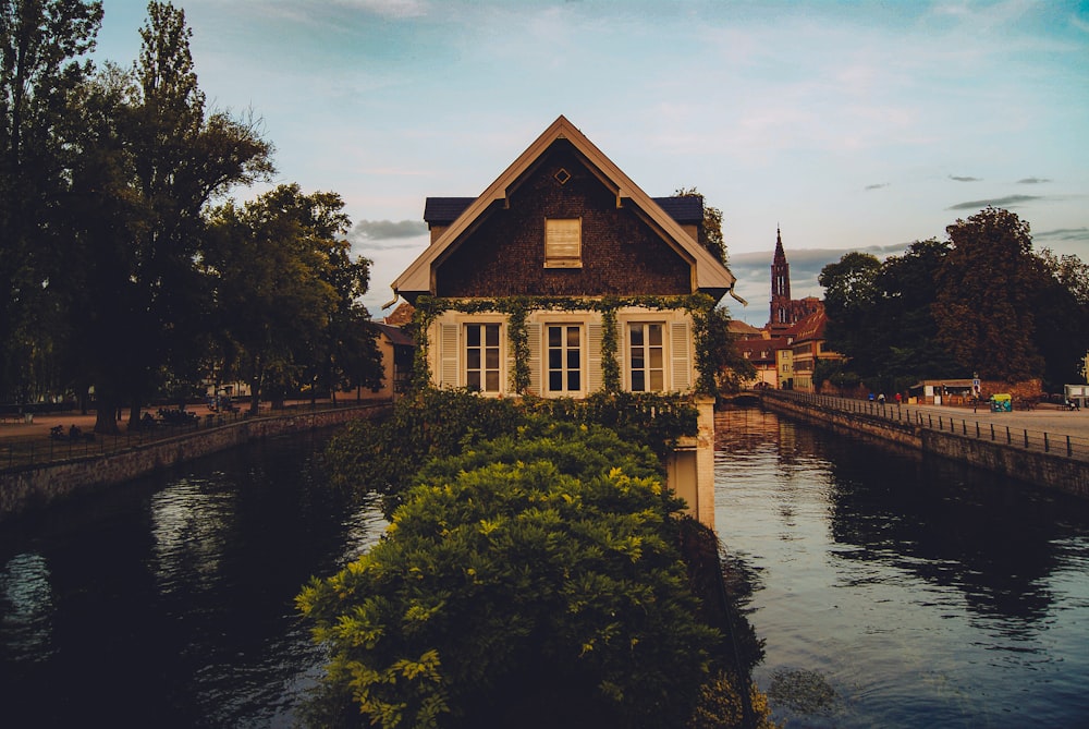 brown and white house beside river during daytime