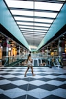woman in white and black polka dot dress walking on gray and white floor tiles