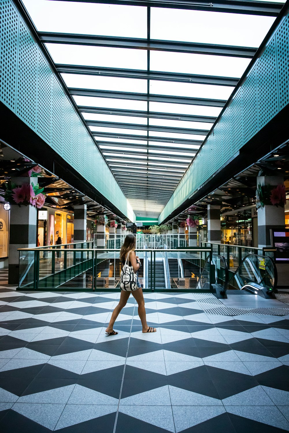 woman in white and black polka dot dress walking on gray and white floor tiles