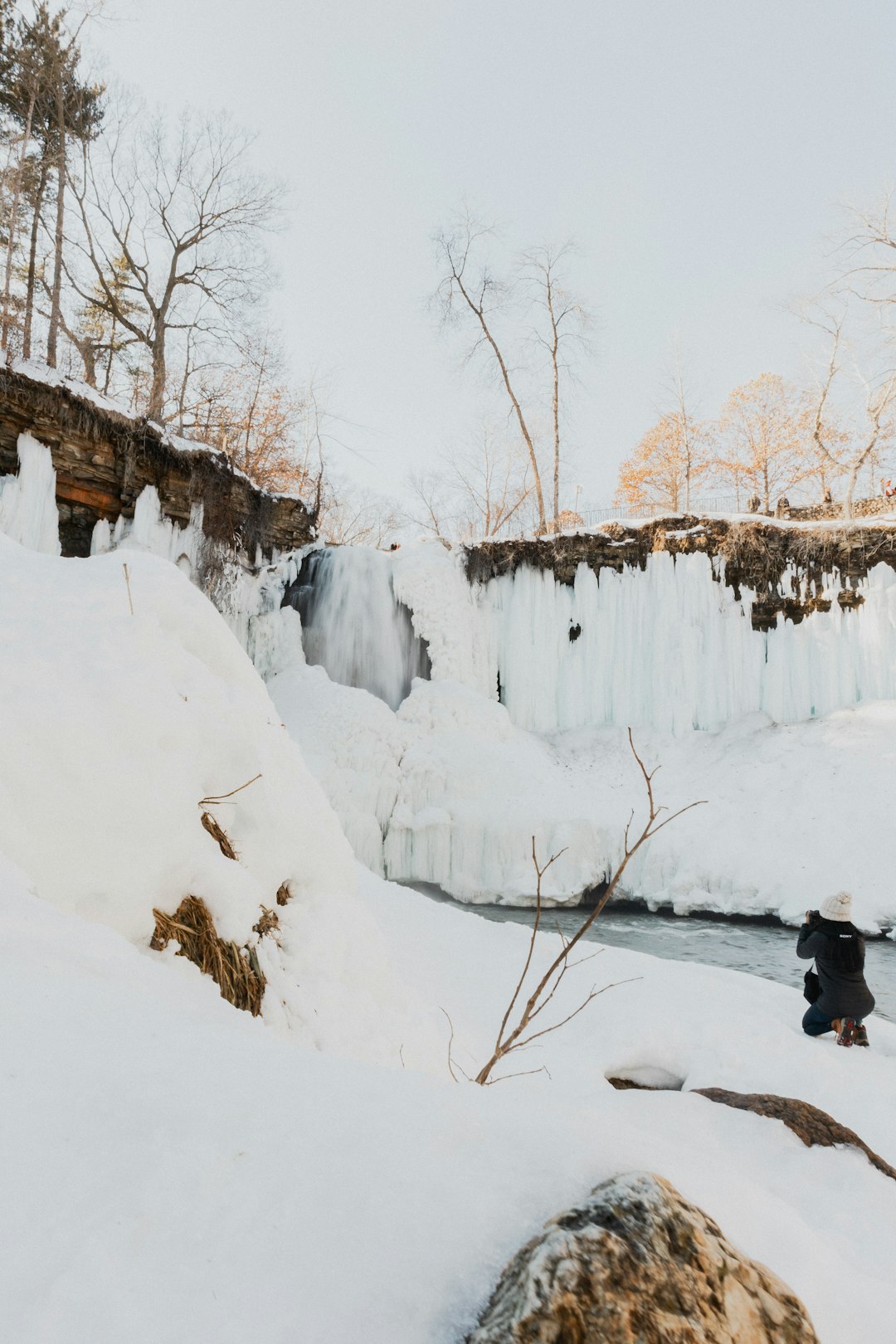 person in black jacket and black pants sitting on snow covered ground during daytime