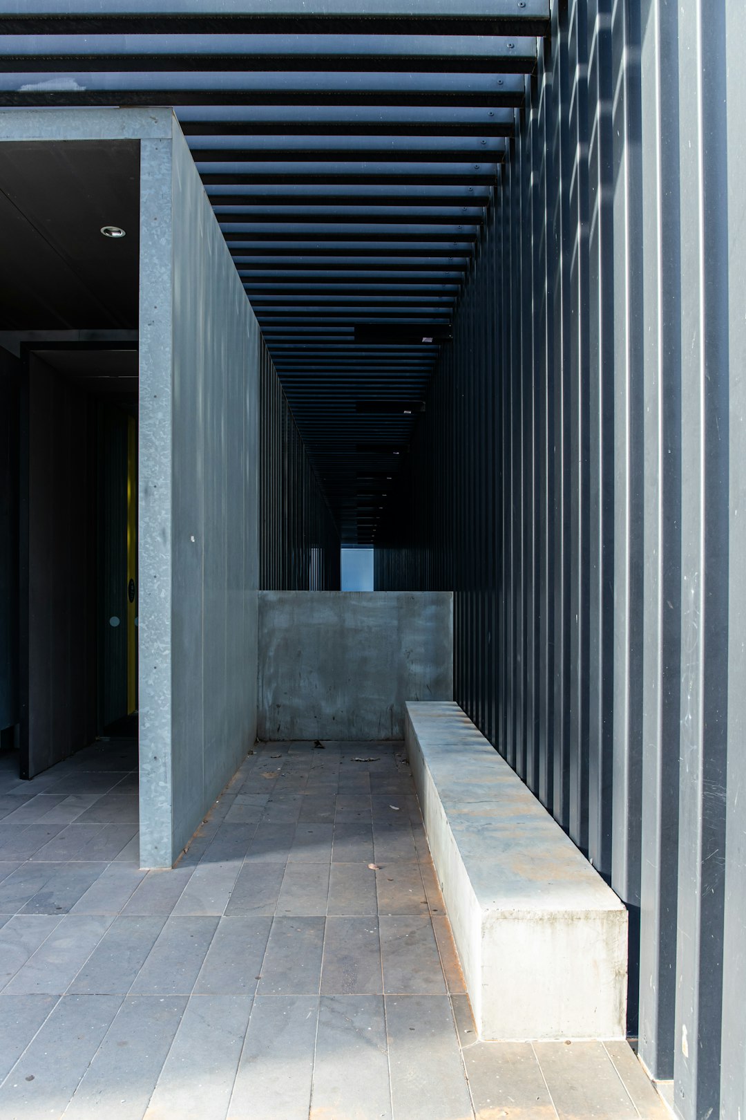 gray concrete hallway with black metal doors