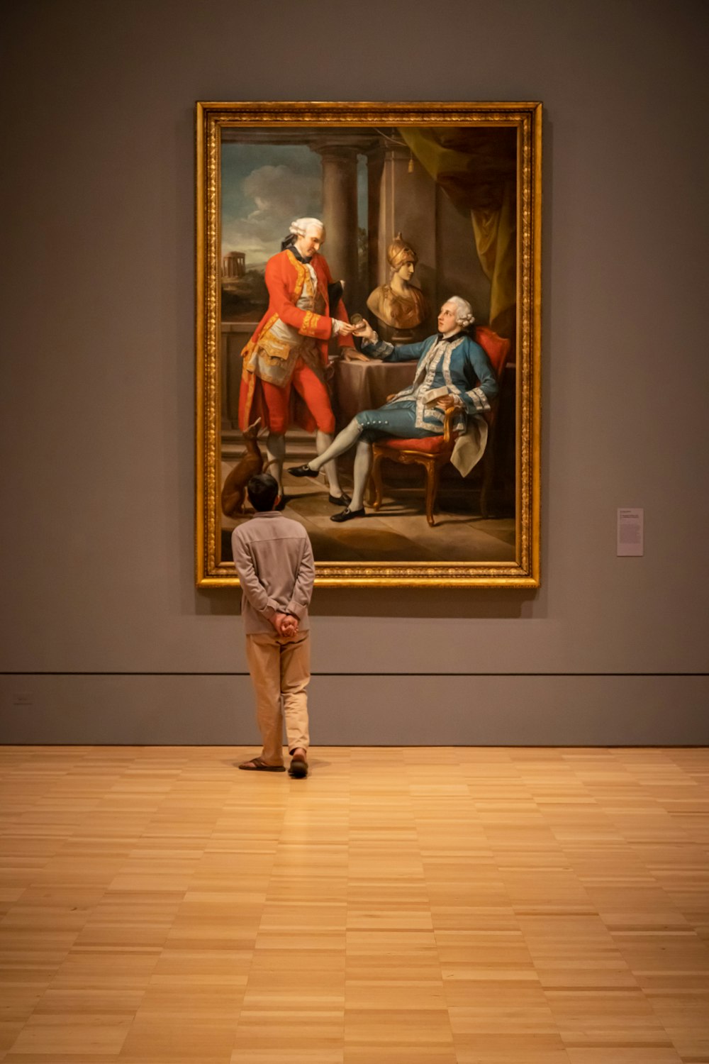 woman in red dress sitting on chair beside woman in blue dress painting