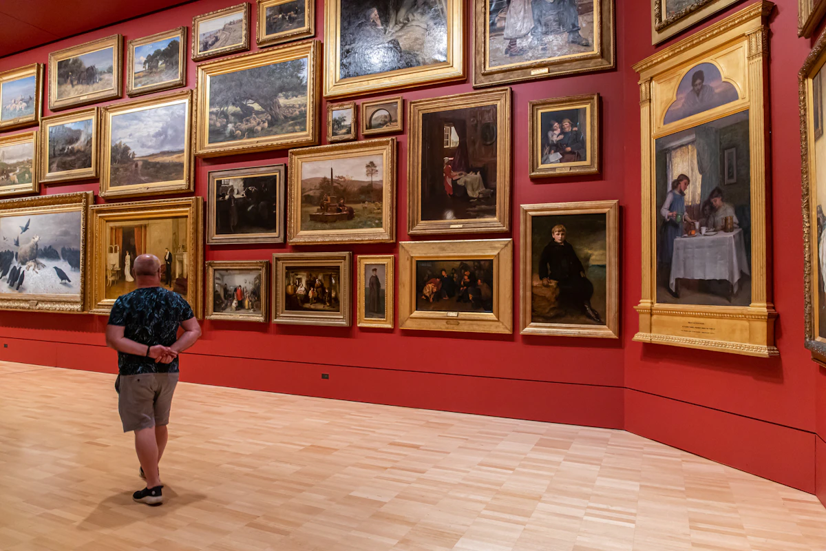 Visitors exploring framed paintings in an art gallery