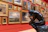 Photo of a middle-aged man admiring a sculpture in a sunlit gallery space filled with colorful artworks.