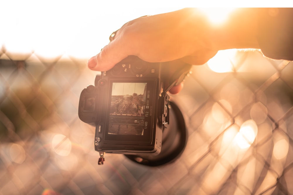 person holding black dslr camera