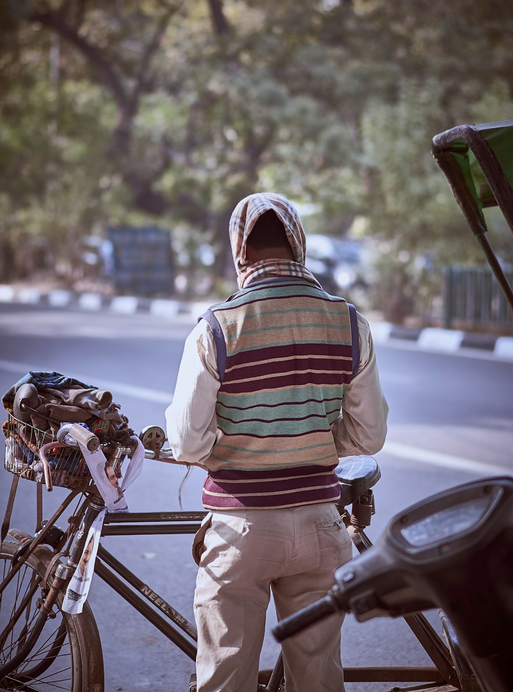 man in white red and blue stripe hoodie standing beside red motorcycle during daytime