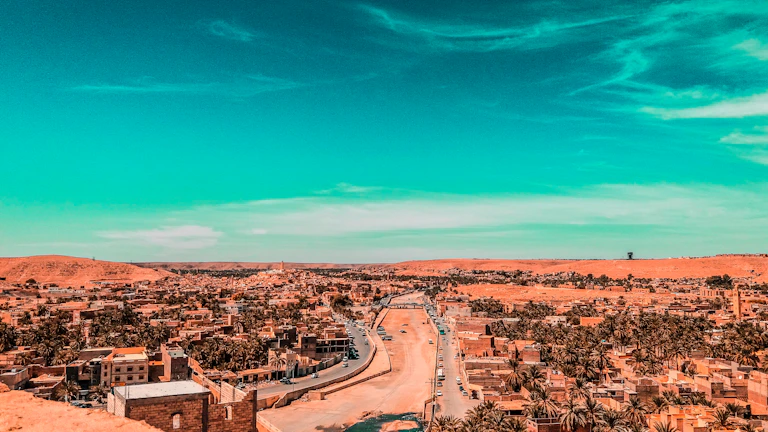 A panoramic view of Marrakech cityscape with a luxury vehicle in the foreground.