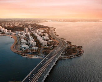 Aerial drone shot capturing a sprawling Miami waterfront estate at sunset.
