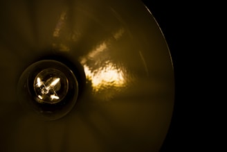 Close-up of a lamp’s high-transparency glass shade reflecting warm light.
