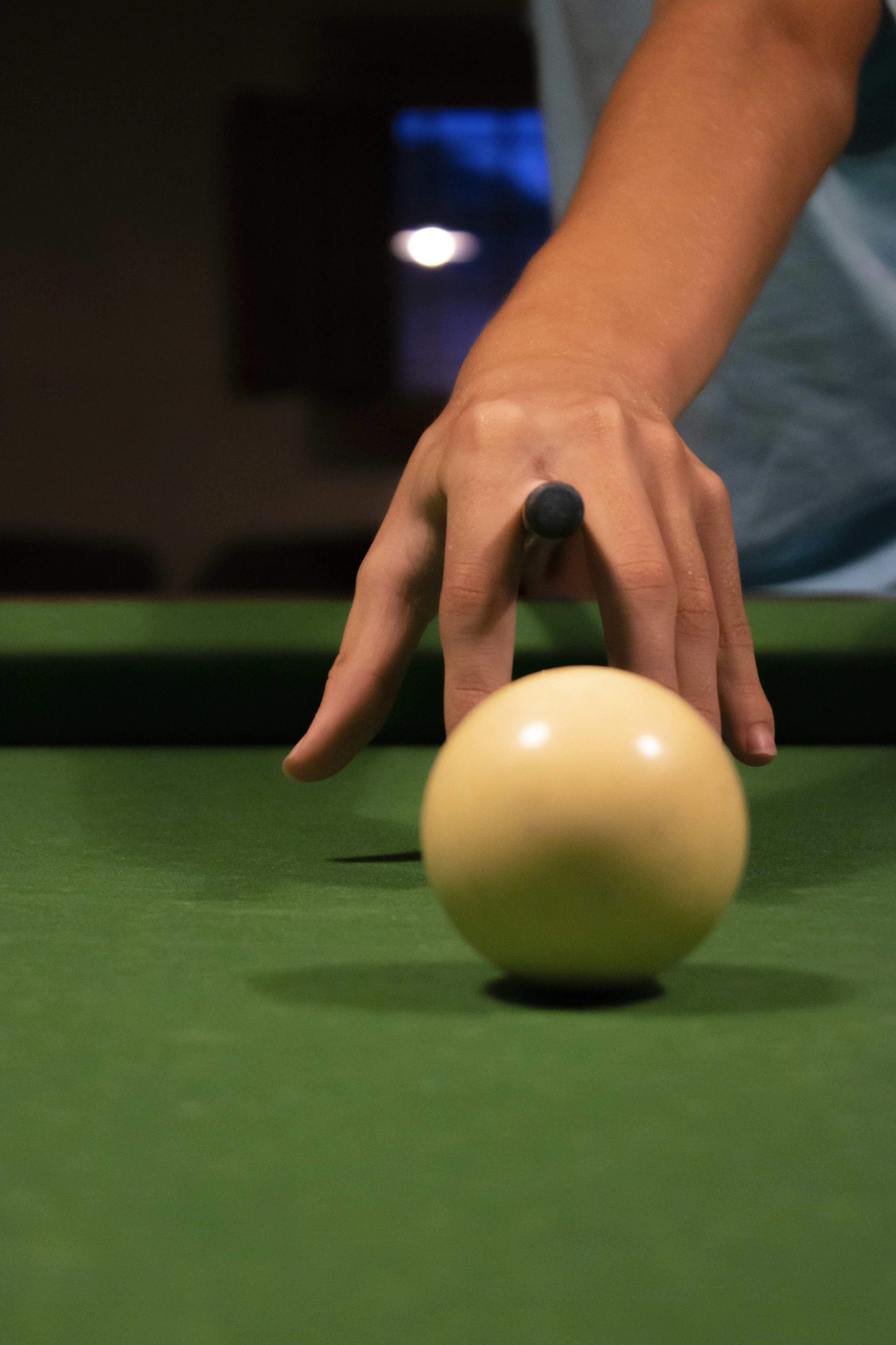 person holding yellow ball on green billiard table