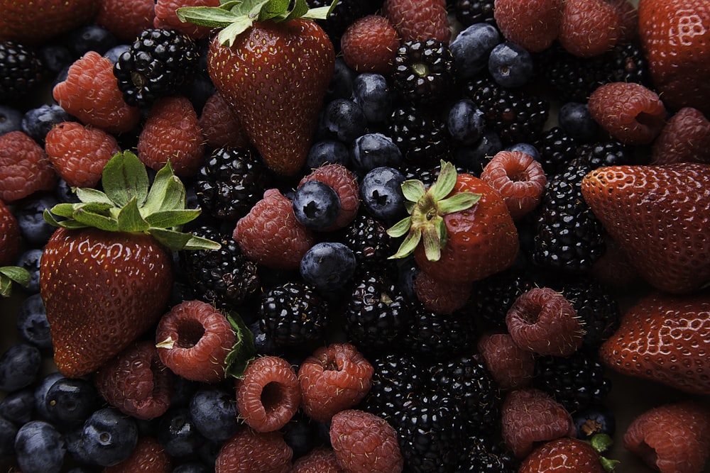 Erdbeeren und Heidelbeeren auf weißer Keramikplatte