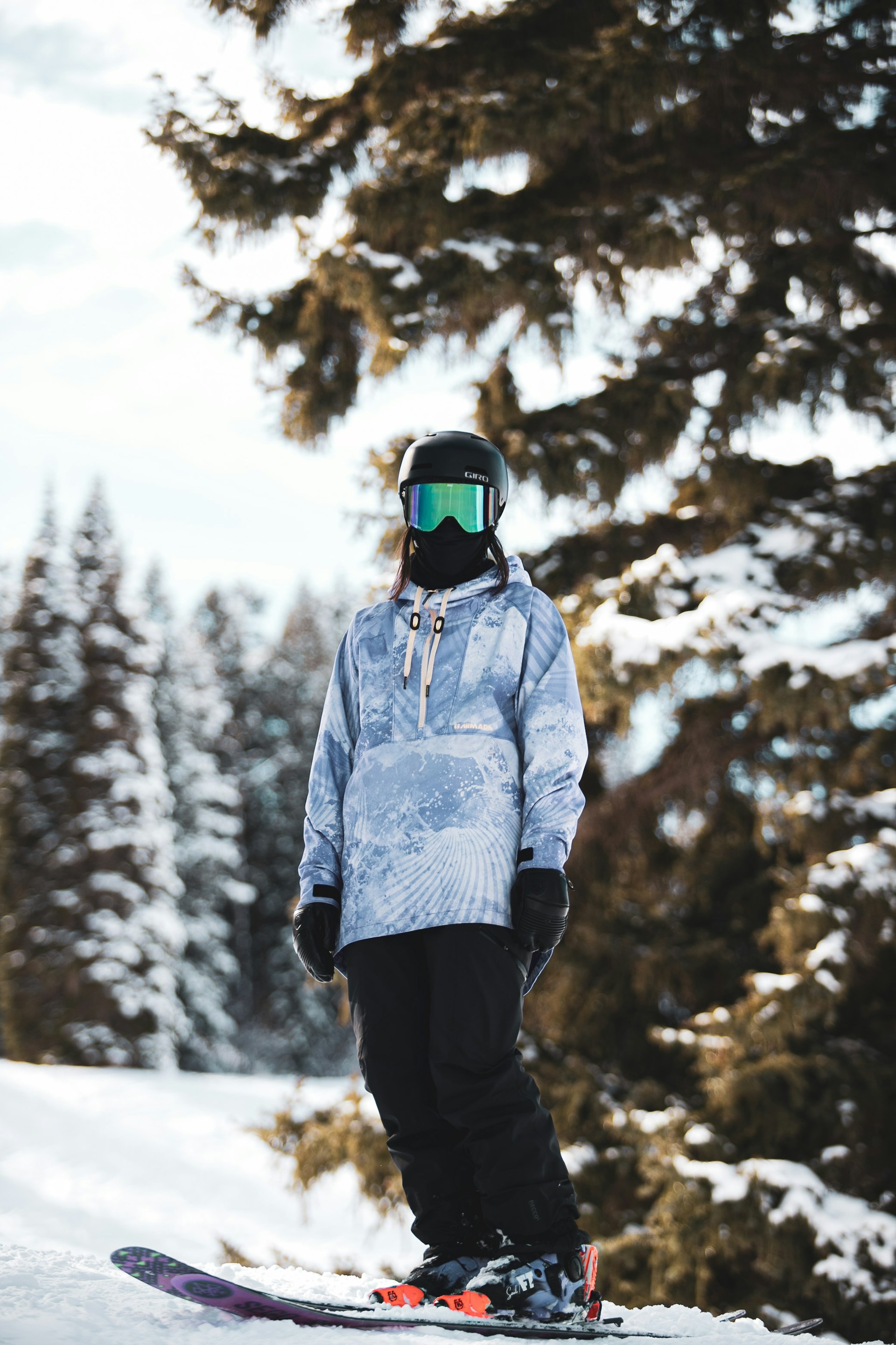 man in blue jacket and black pants standing on snow covered ground during daytime