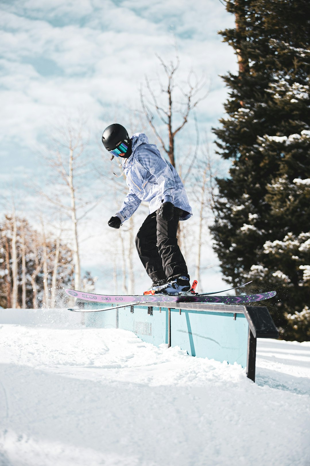 man in blue jacket and black pants riding on snowboard during daytime