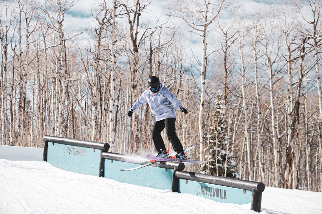 man in blue jacket and black pants riding on snowboard during daytime