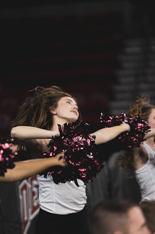 A dynamic shot of a cheerleader mid-jump wearing a sleek, coordinated team outfit.