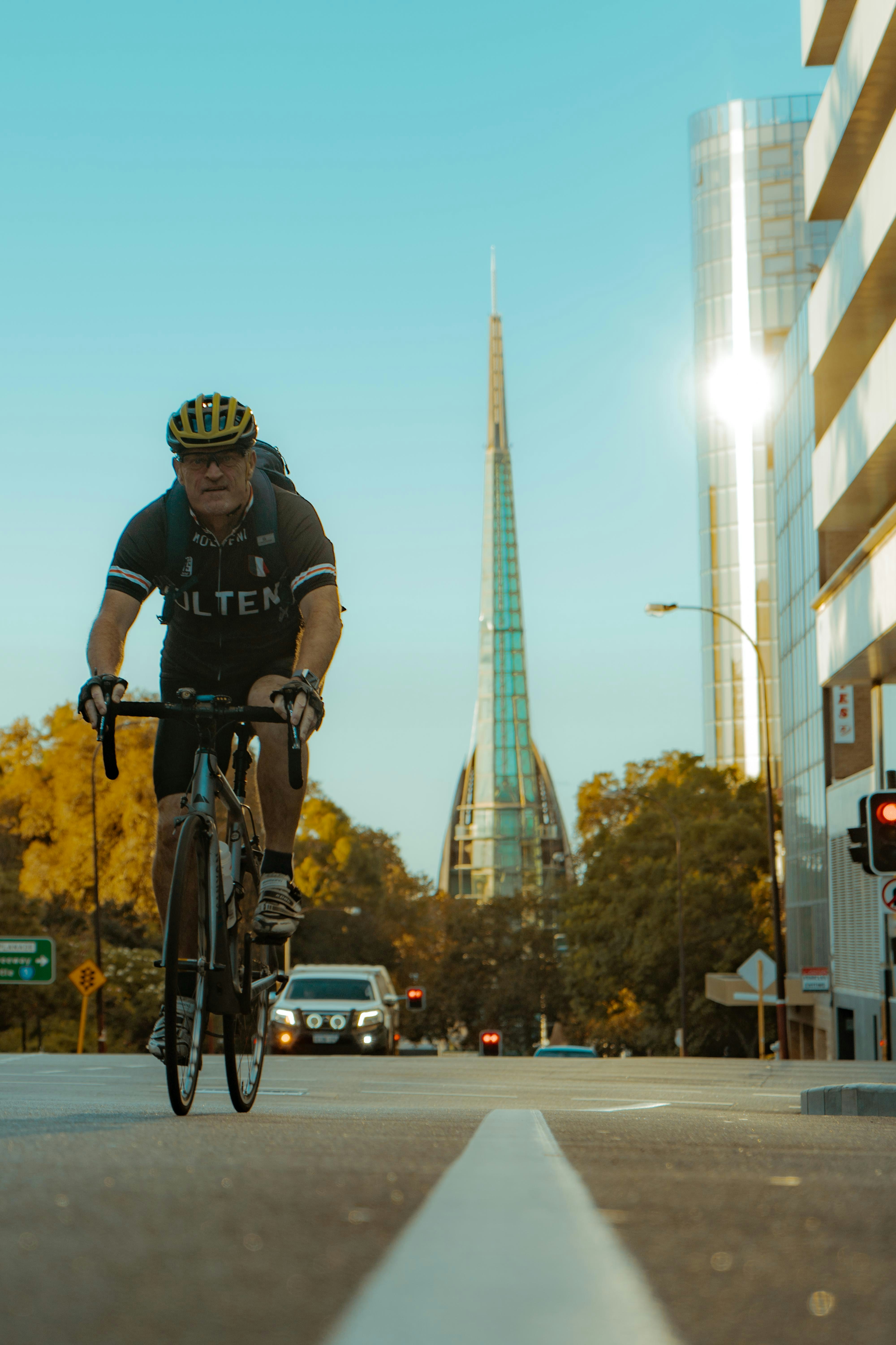 man in black jacket riding bicycle on road during daytime