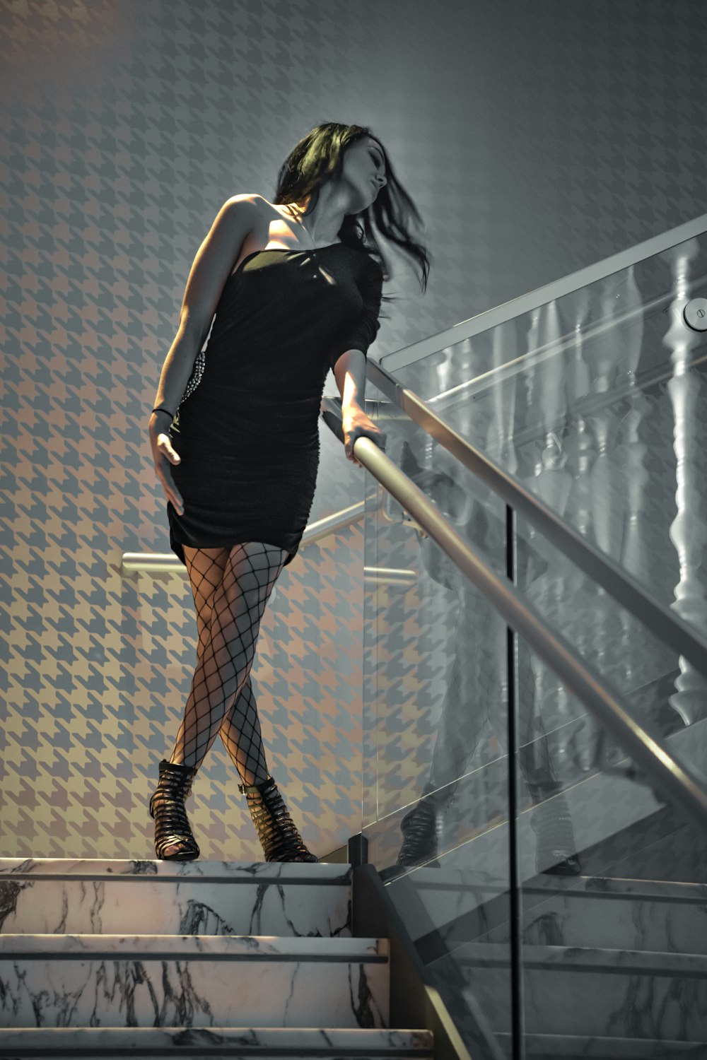 검은 민소매 셔츠와 갈색 치마를 입은 여자가 계단에 서 있다