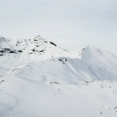 A snow-plastered summit ridge at Laax with ski tracks cutting below rock bands