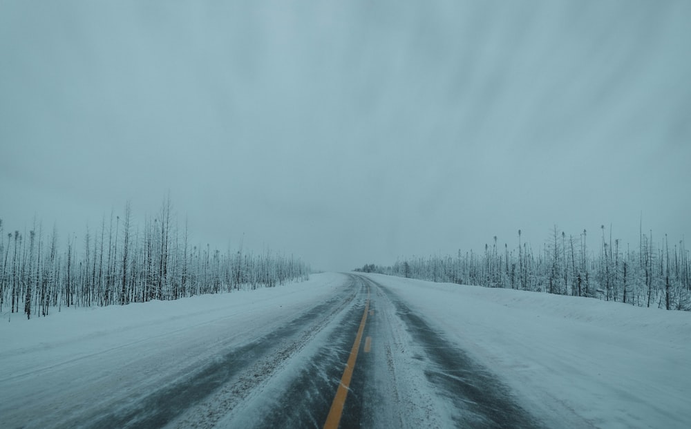 black asphalt road covered with snow