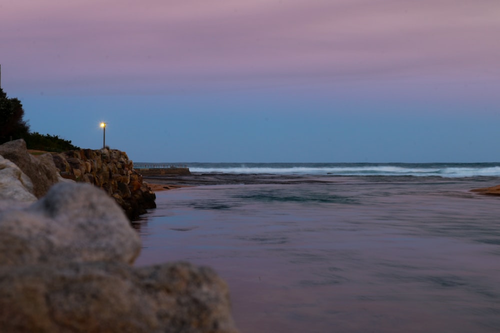 person standing on rock near sea during daytime