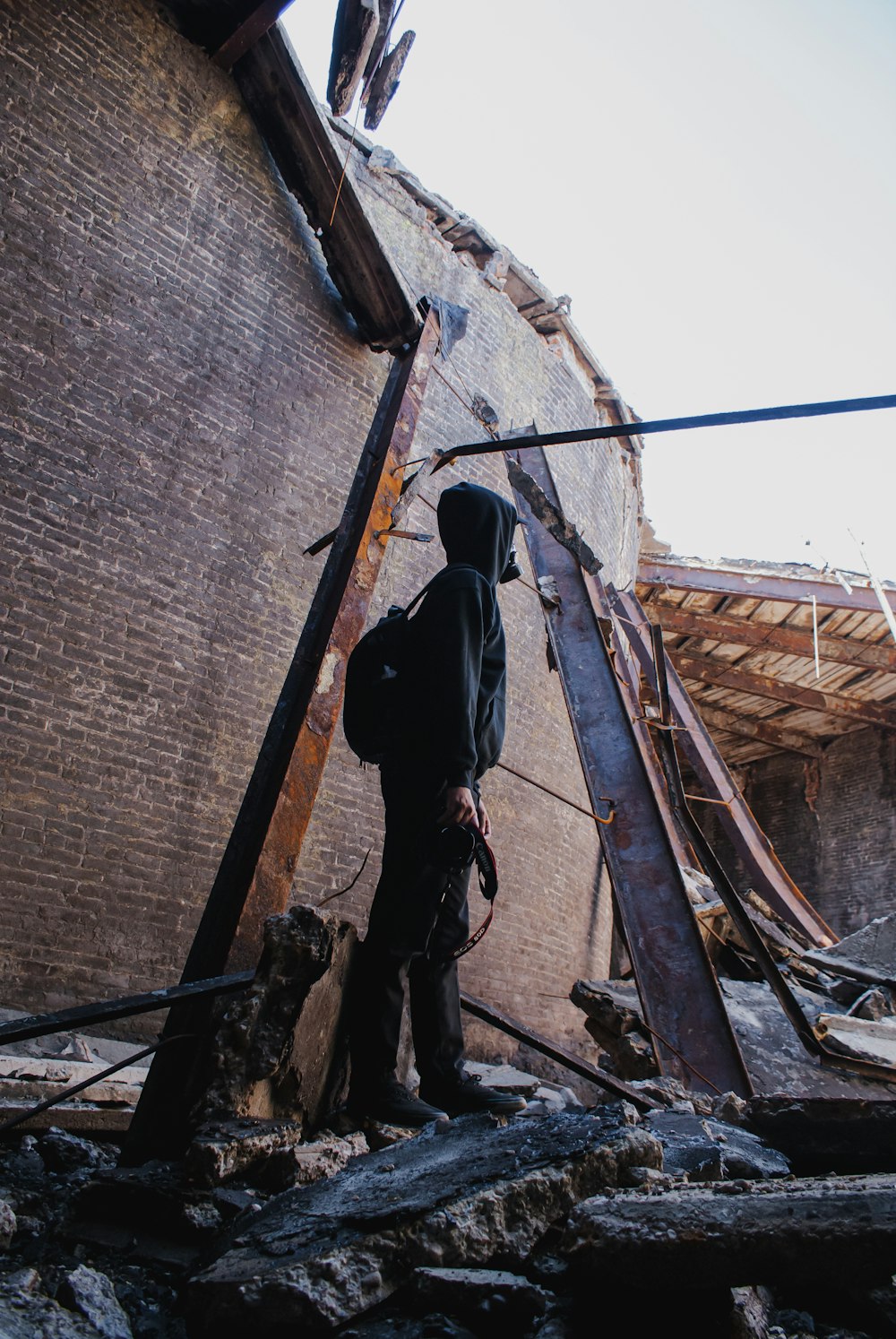 man in black jacket and black pants climbing on ladder