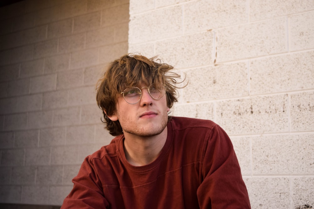 man in red crew neck shirt wearing black framed eyeglasses