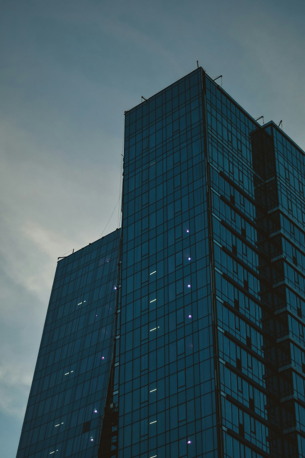 青と黒のガラス張りの高層ビル