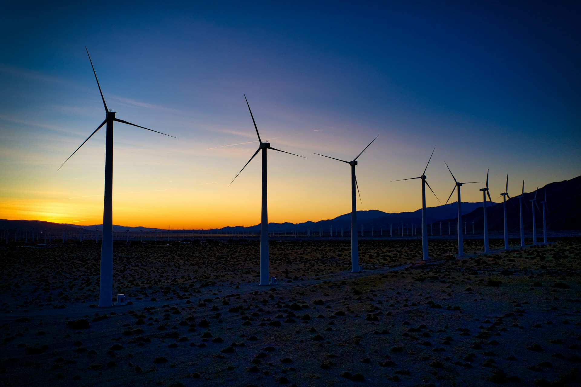 wind turbines on brown sand during sunset