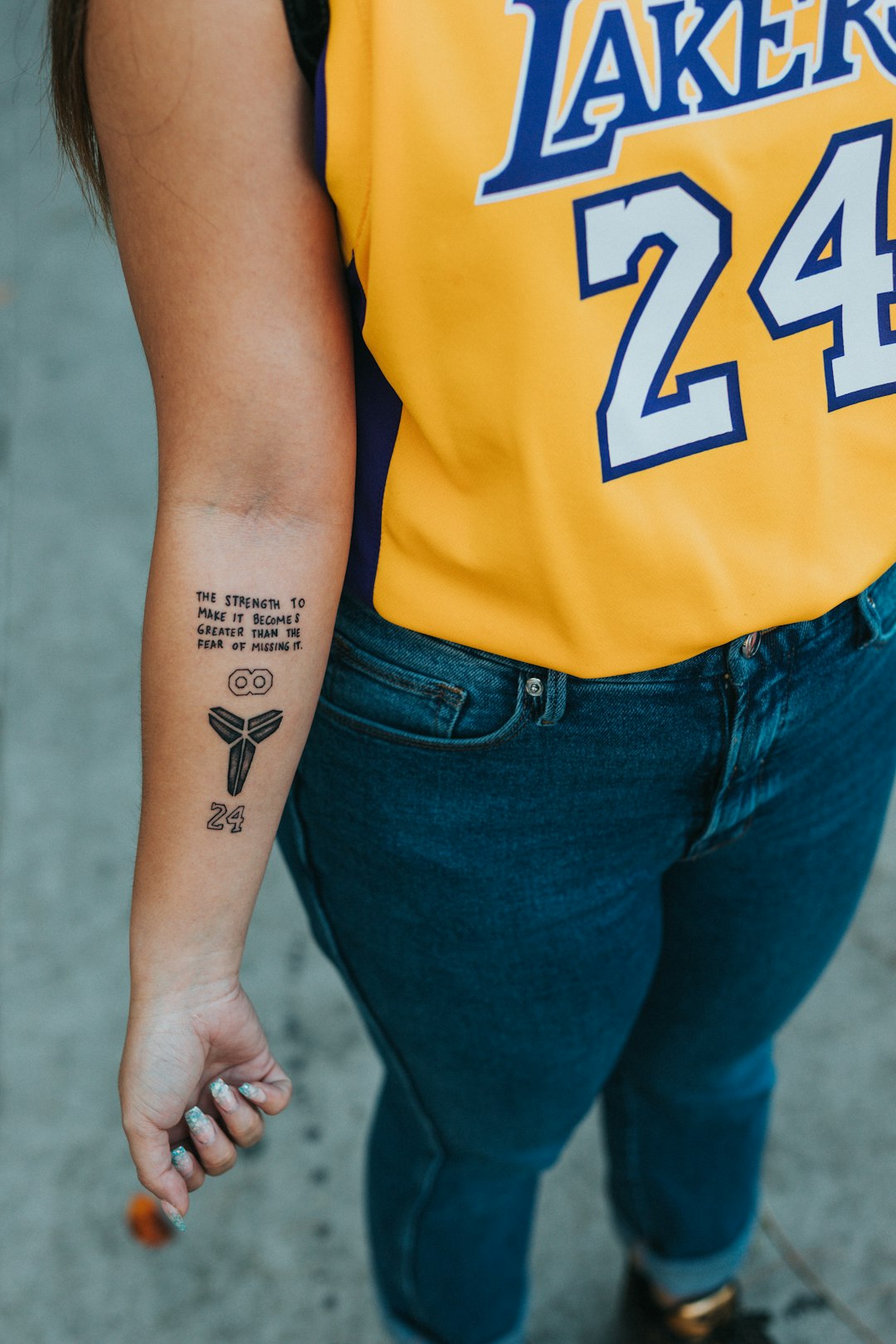 person in yellow and blue t-shirt with tattoo on right arm