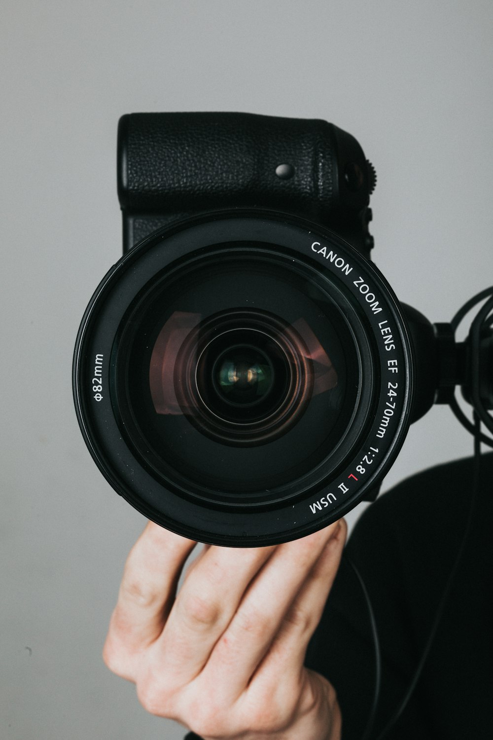 Schwarze Nikon DSLR-Kamera an Personenhand