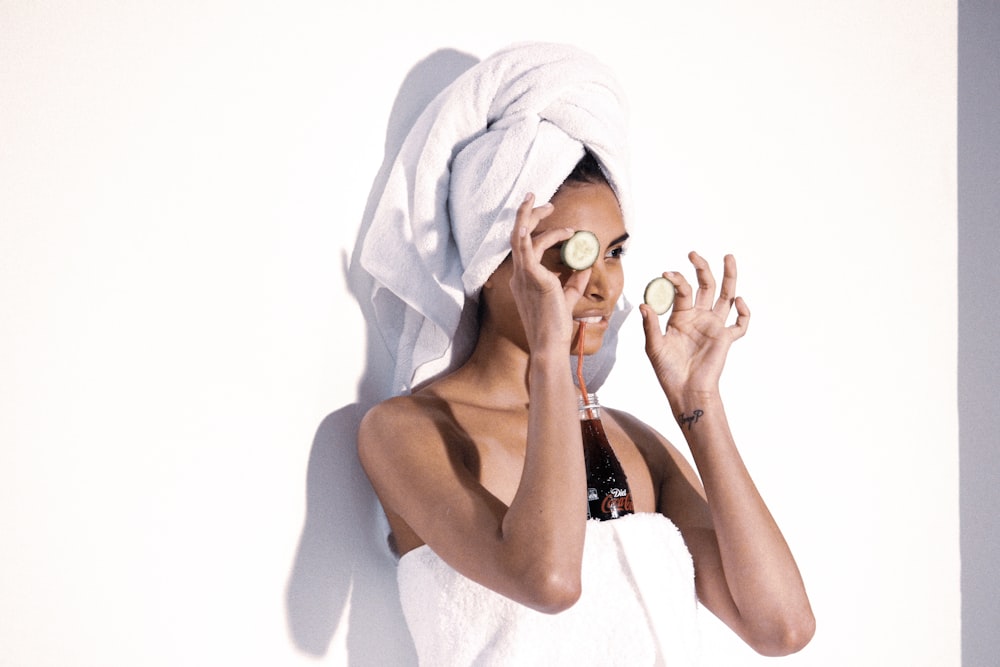 woman in white towel covering her face with blue towel