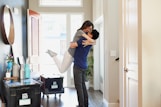 woman in gray long sleeve shirt and gray pants standing beside white wooden door