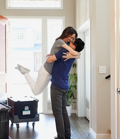 woman in gray long sleeve shirt and gray pants standing beside white wooden door