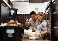 Smiling customers unboxing products in a cozy home setting.