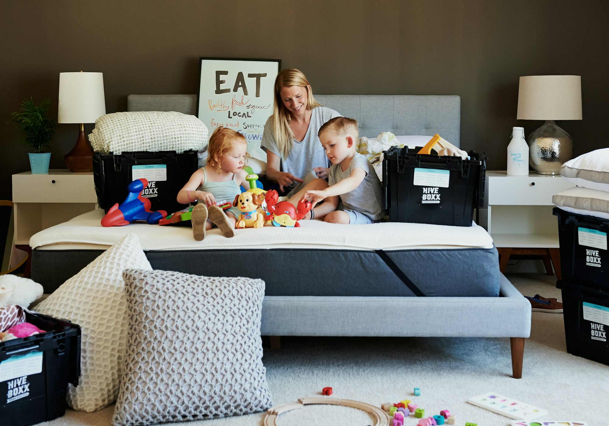 Mother and children playing toys from storage boxes.