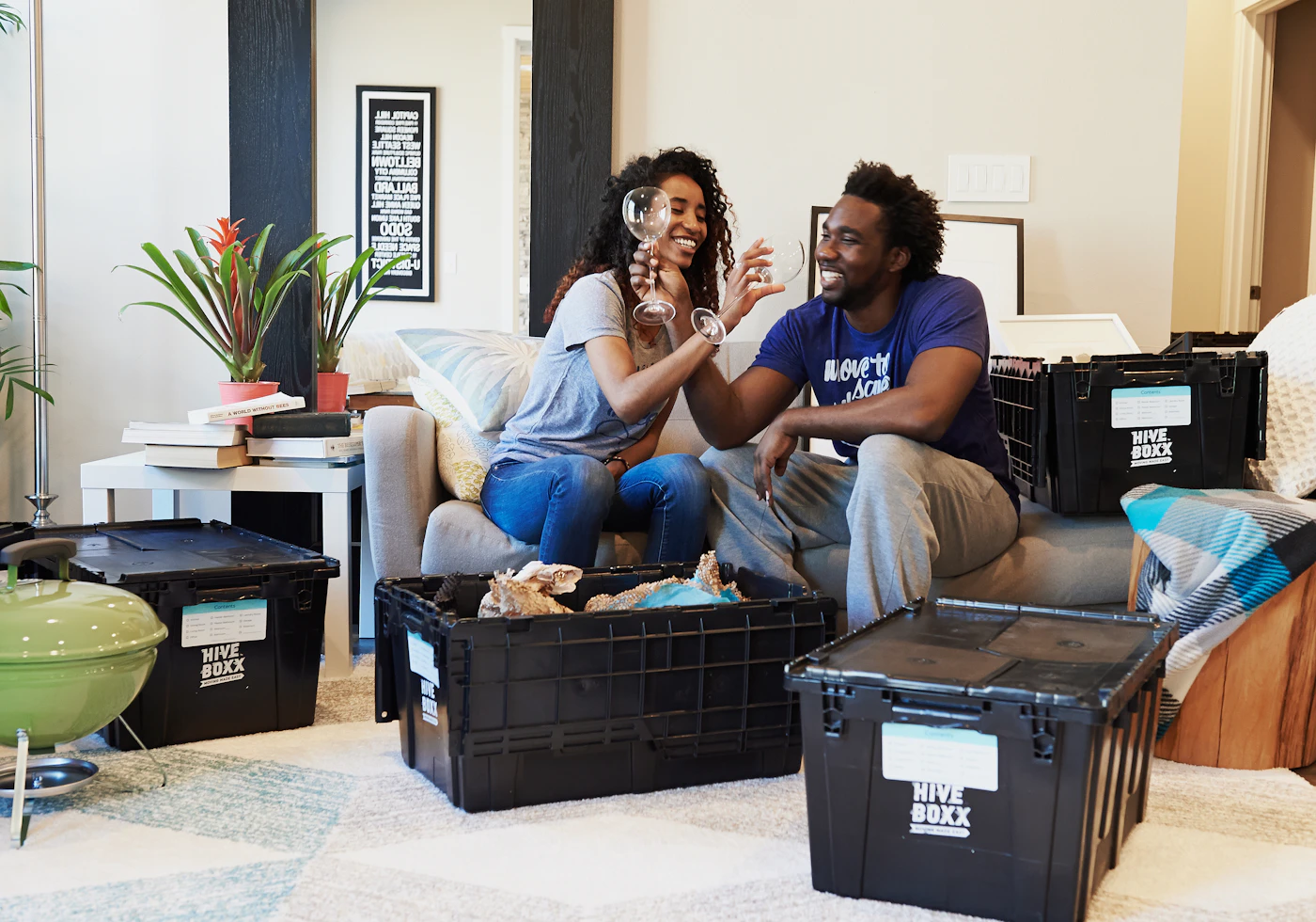 Couple laughing while unpacking in their living room