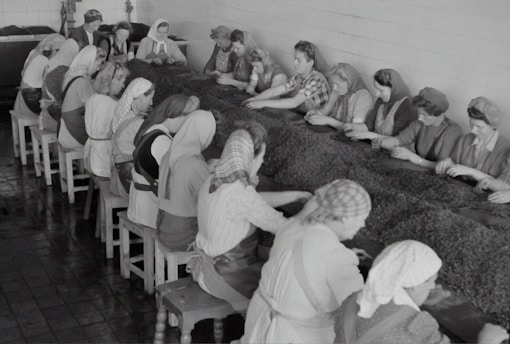 A group of workers in industrial uniforms collaborating on a project in a modern workspace.