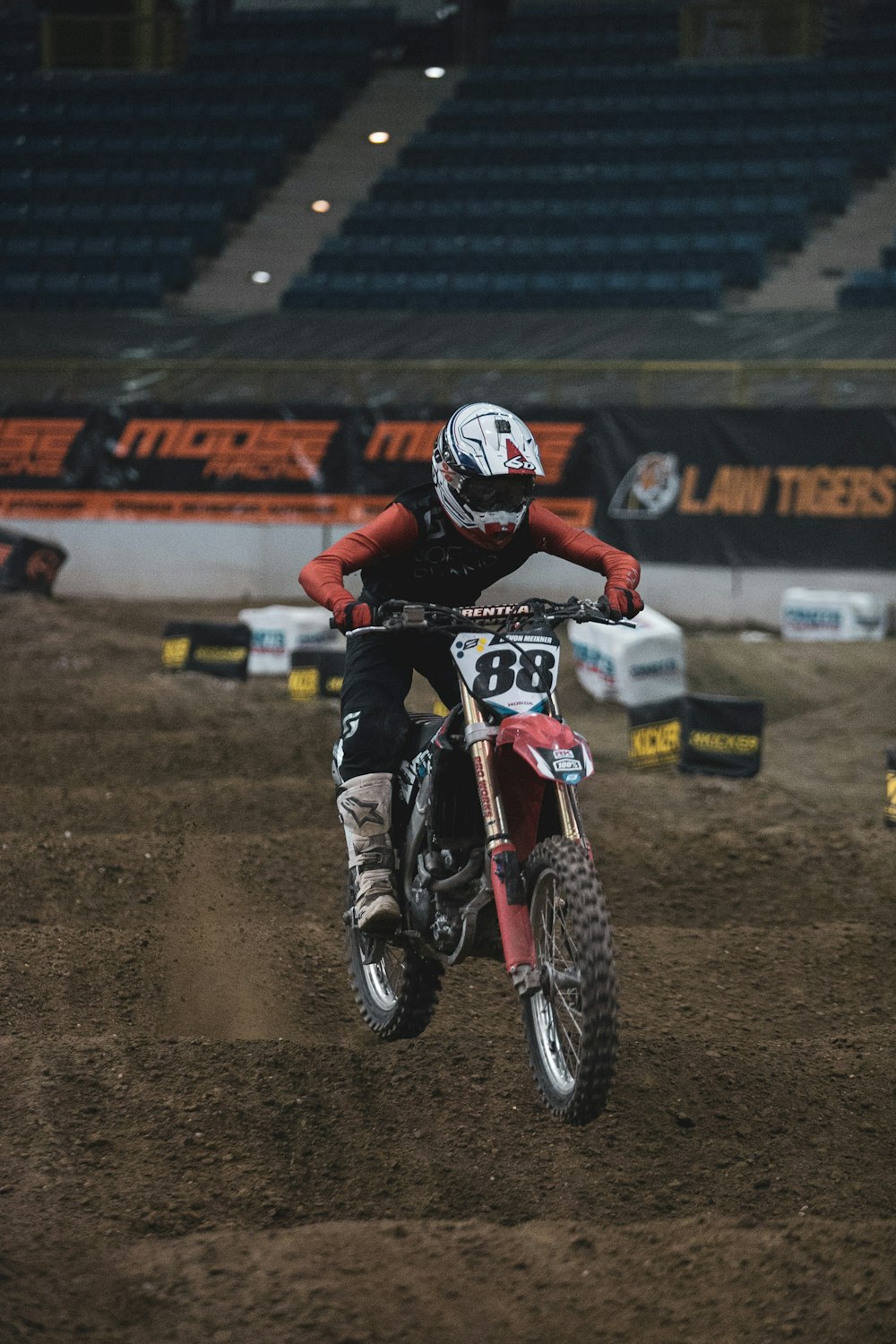 man in red and white motorcycle suit riding on red dirt bike