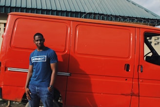 A confident tradie checking his phone with a satisfied smile, standing outside his local work van.