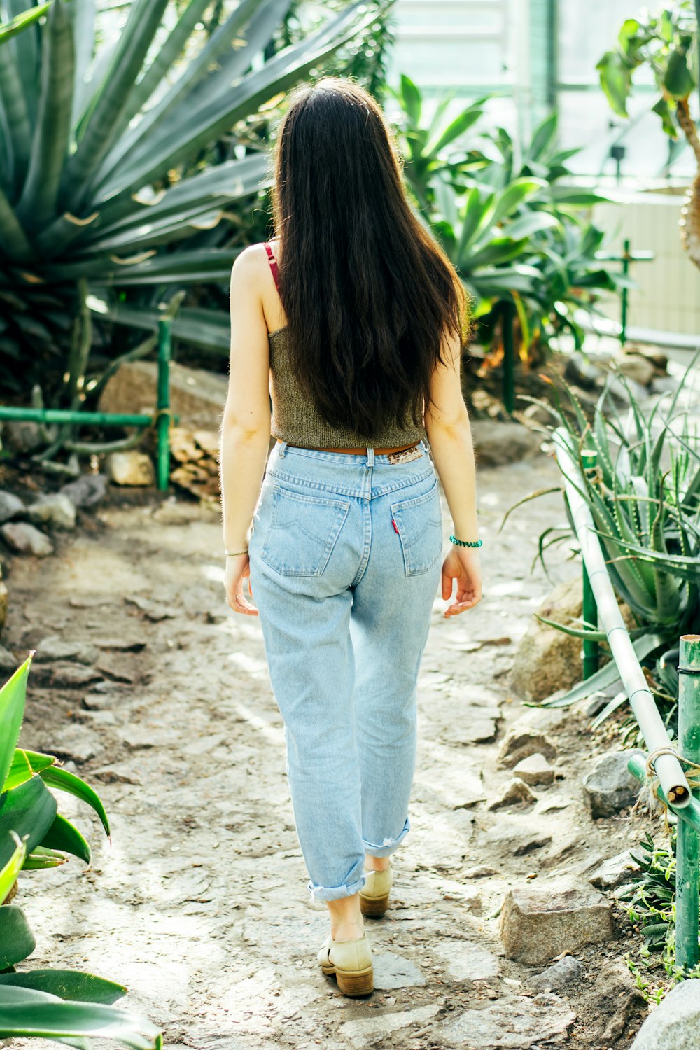 woman in blue denim jeans standing on gray sand during daytime