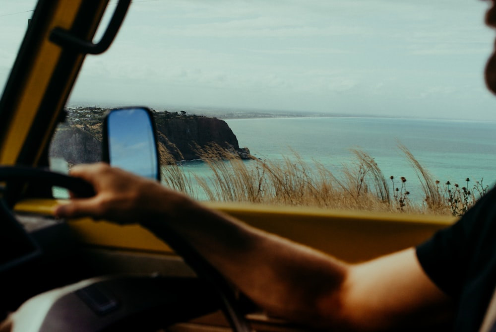 person holding black smartphone taking photo of body of water during daytime