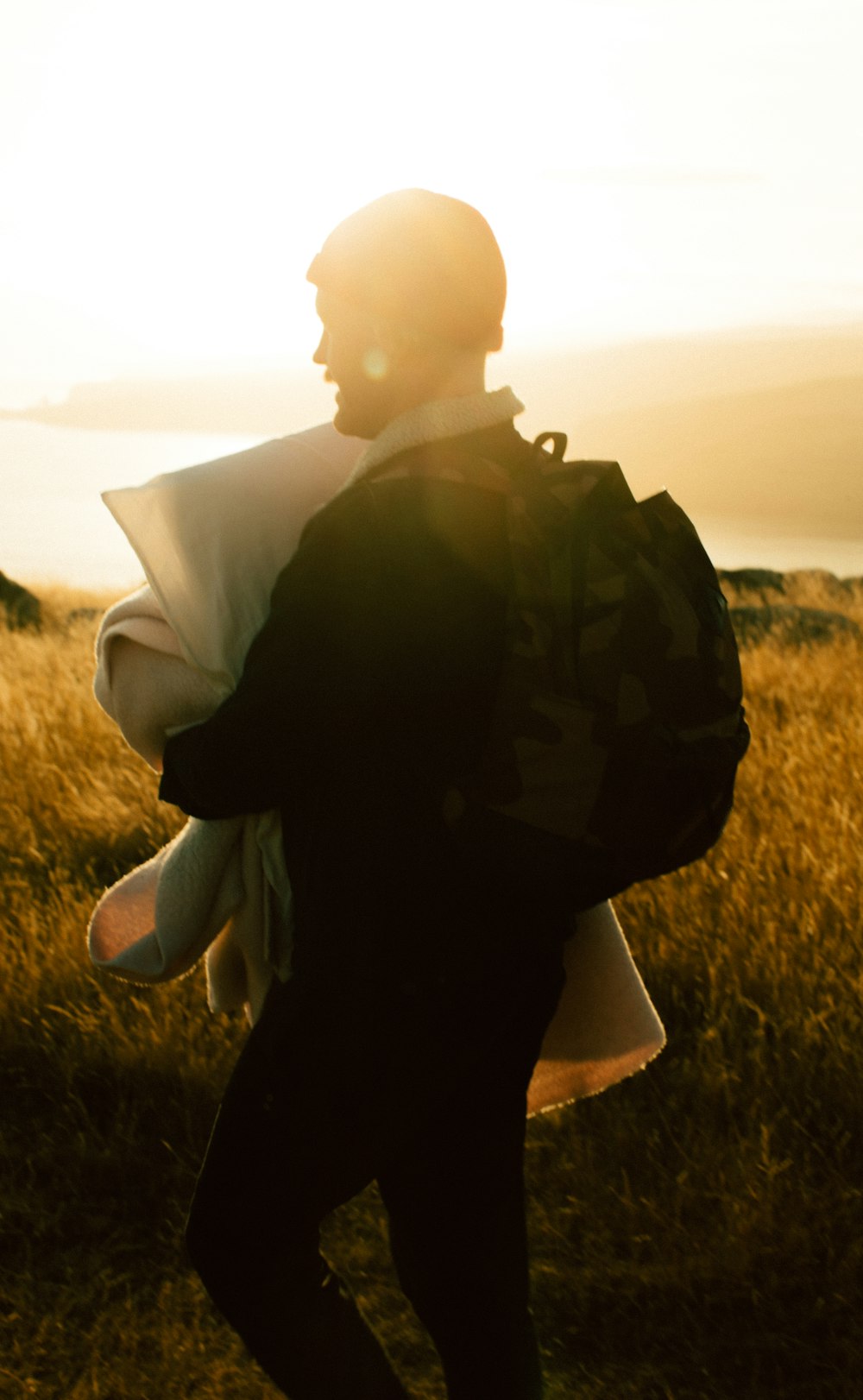 man in black jacket standing on green grass field during daytime