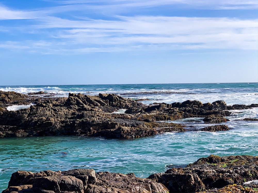 brown rocky shore under blue sky during daytime