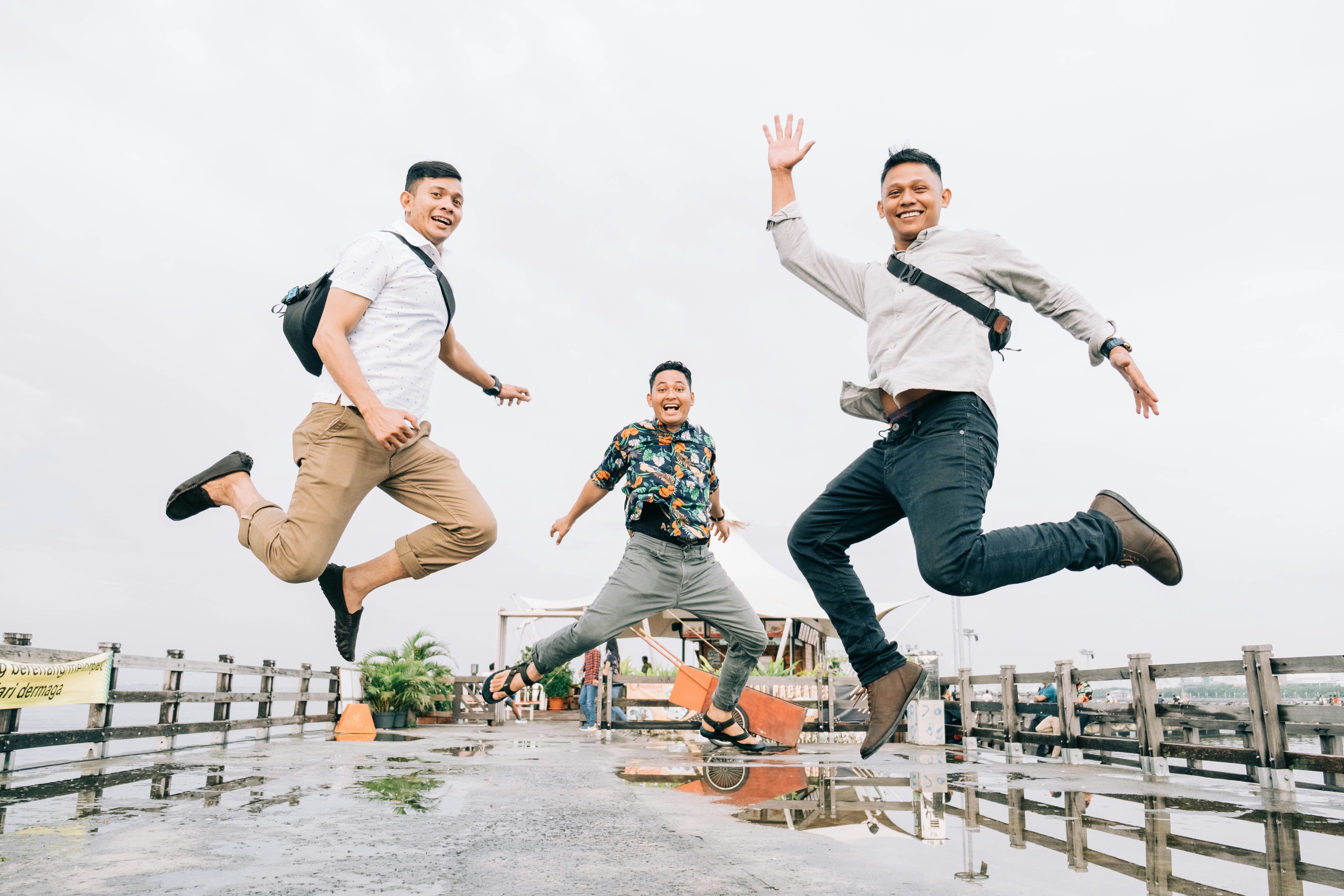 Pria dengan kaos hitam dan jeans denim biru melompat di skateboard oranye dan hitam selama