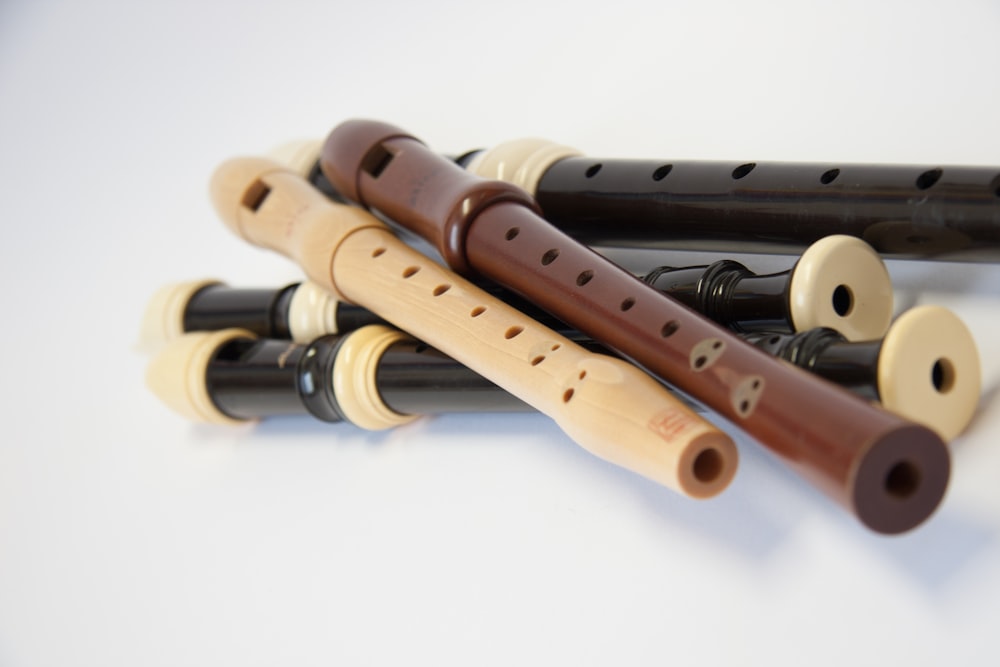 flauta de madera marrón sobre mesa blanca