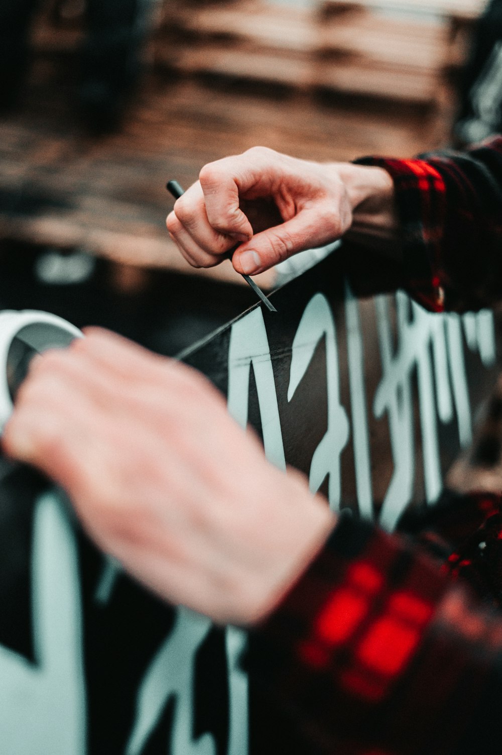 person in red long sleeve shirt holding black and white textile